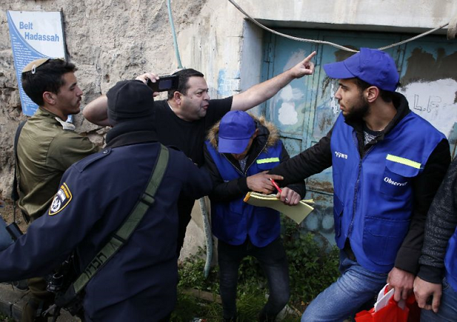 members of the israeli security forces intervene as a jewish settler c shouts at members of the palestinian youth against settlements yas activists r in the occupied west bank town of hebron photo afp