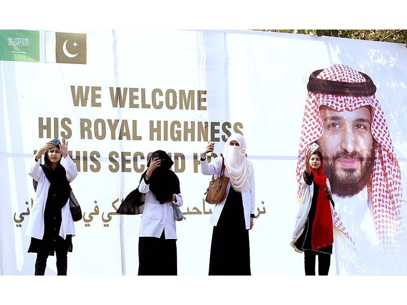 women posing for selfies with signboard erected to welcome saudi crown prince mohammad in islamabad on saturday photo app