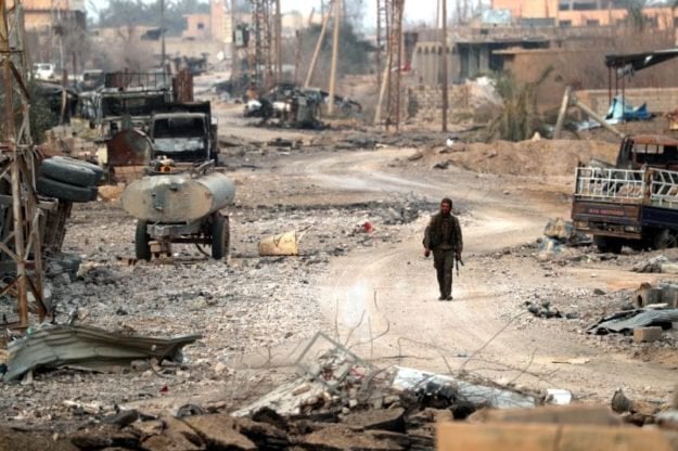 a member of syria 039 s arab shaytat tribe who joined a kurdish led alliance fighting is walks amid debris in the village of baghouz on january 27 2019 photo afp