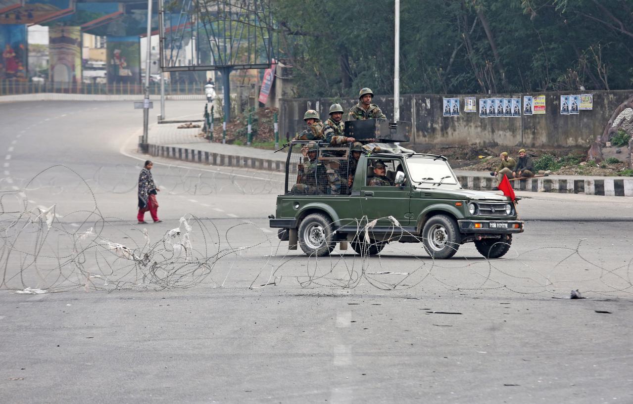 indian army soldiers in a vehicle patrol a street as a woman walks past during a curfew in jammu photo reuters