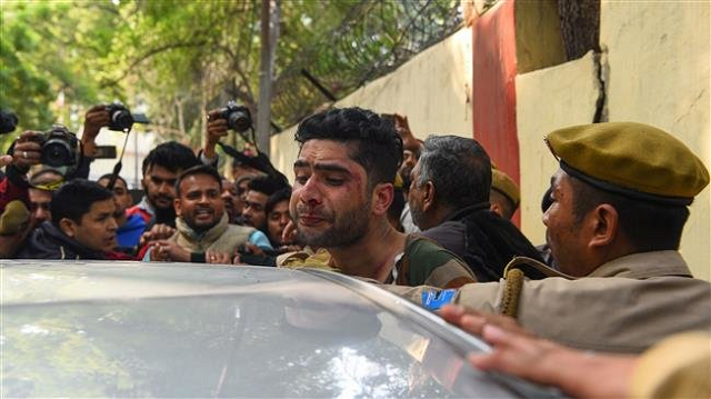 an injured man c believed to be a kashmiri assaulted by an angry mob is shielded by indian policemen in new delhi india on february 17 2019 photo afp an injured man c believed to be a kashmiri assaulted by an angry mob is shielded by indian policemen in new delhi india on february 17 2019 photo afp