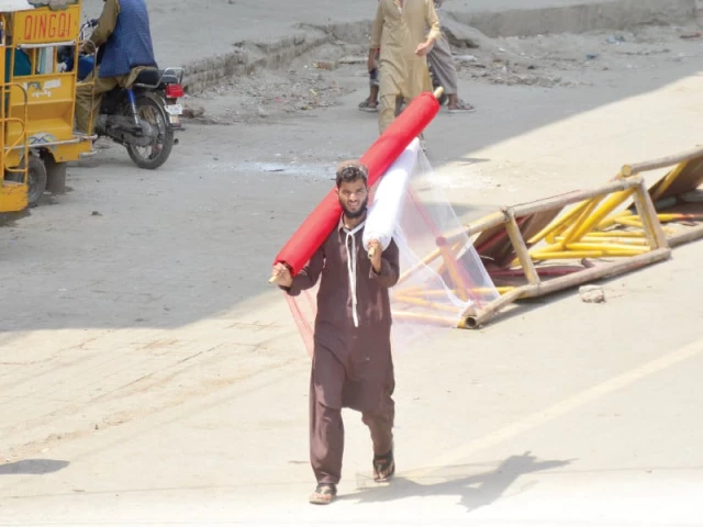 a labourer carries brightly coloured rolls of net curtains on his shoulders for sale on city saddar road aiming to attract customers seeking relief from the scorching heat and protection against insects photo agha mahroz express a labourer carries brightly coloured rolls of net curtains on his shoulders for sale on city saddar road aiming to attract customers seeking relief from the scorching heat and protection against insects photo agha mahroz express