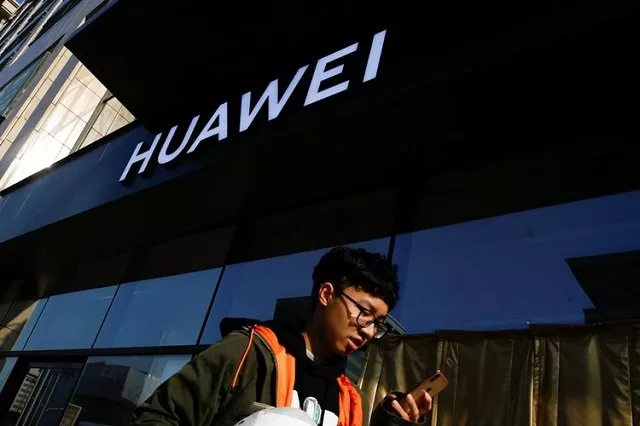 a man uses his phone as he walks past a huawei shop in beijing china december 19 2018 photo reuters a man uses his phone as he walks past a huawei shop in beijing china december 19 2018 photo reuters