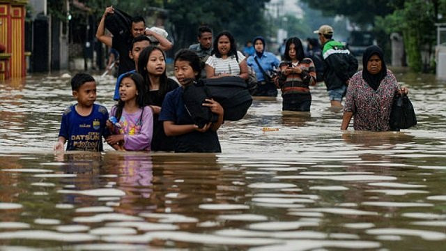 residents walking along a flooded road as they evacuate dayeuhkolot village in bandung photo afp residents walking along a flooded road as they evacuate dayeuhkolot village in bandung photo afp