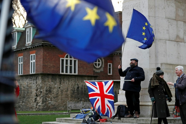 an anti brexit activist waves an eu flag and a union jack flag as he demonstrates opposite the houses of parliament in central london on january 9 2019 photo afp