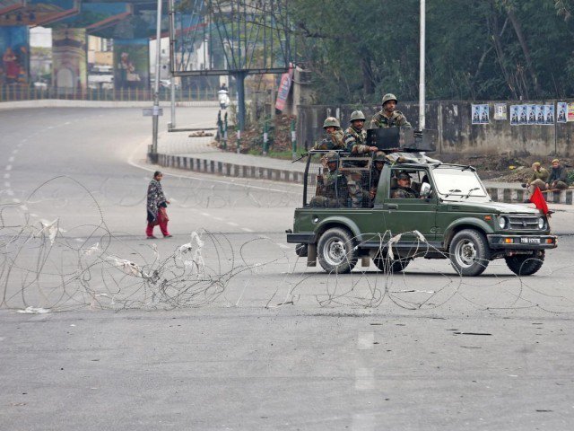 indian soldiers in a vehicle patrol a street as a woman walks past during a curfew in occupied kashmir photo reuters file