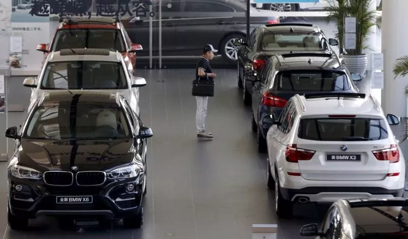a man checks out luxury vehicles at a showroom photo reuters a man checks out luxury vehicles at a showroom photo reuters