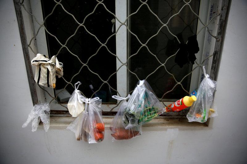 groceries in plastic bags hang by a window photo reuters