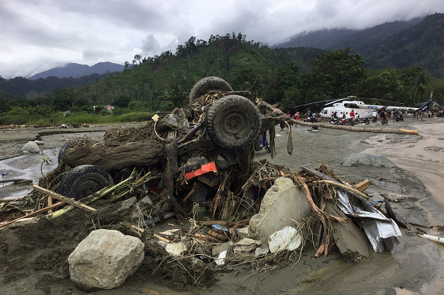 the wreckage of a vehicle swept away by flash floods is seen in sentani near the provincial capital of jayapura indonesia 039 s eastern papua province on march 17 2019 photo afp