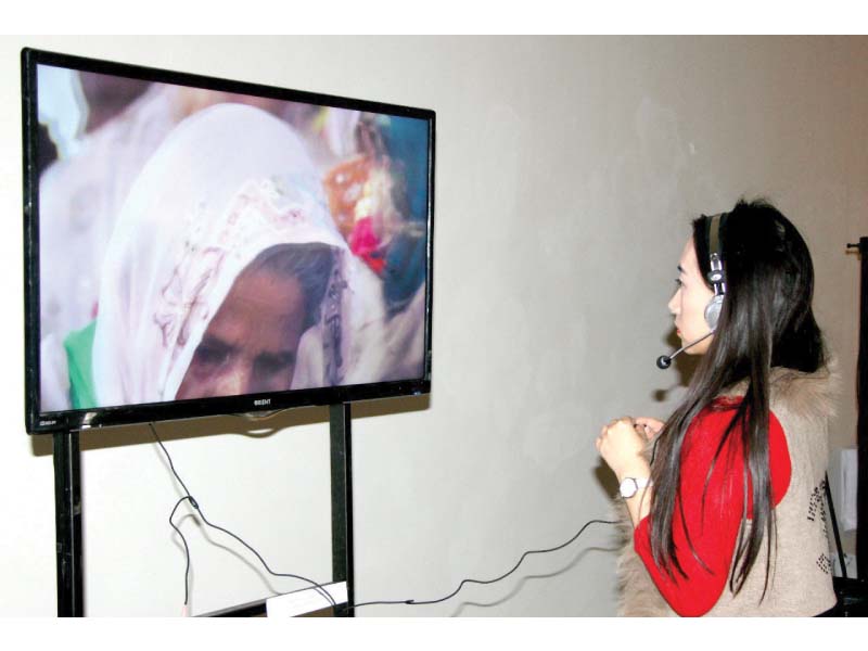 visitor at the ahang travelling exhibition admiring a video installation at the show photo express