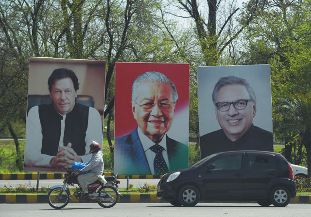 portraits of prime minister imran khan l president arif alvi r along with malaysia 039 s prime minister mahathir mohamad c on the constitution avenue in islamabad on march 21 2019 photo afp