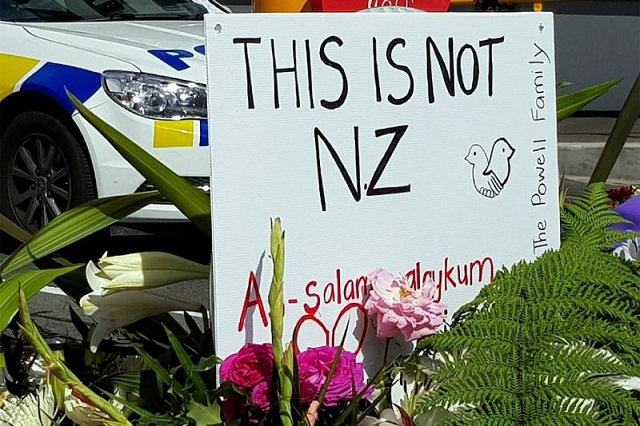 a message is seen as residents pay their respects by placing flowers for the victims of the mosques attacks in christchurch photo afp