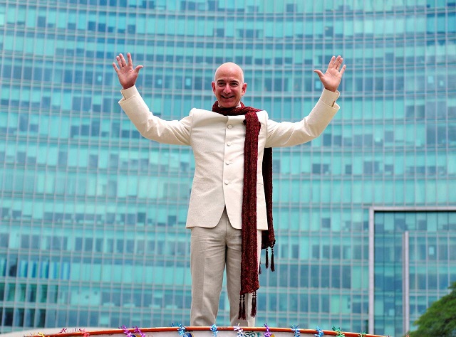 jeff bezos founder and chief executive officer of amazon poses as he stands atop a supply truck during a photo opportunity at the premises of a shopping mall in bangalore india september 28 2014 photo reuters