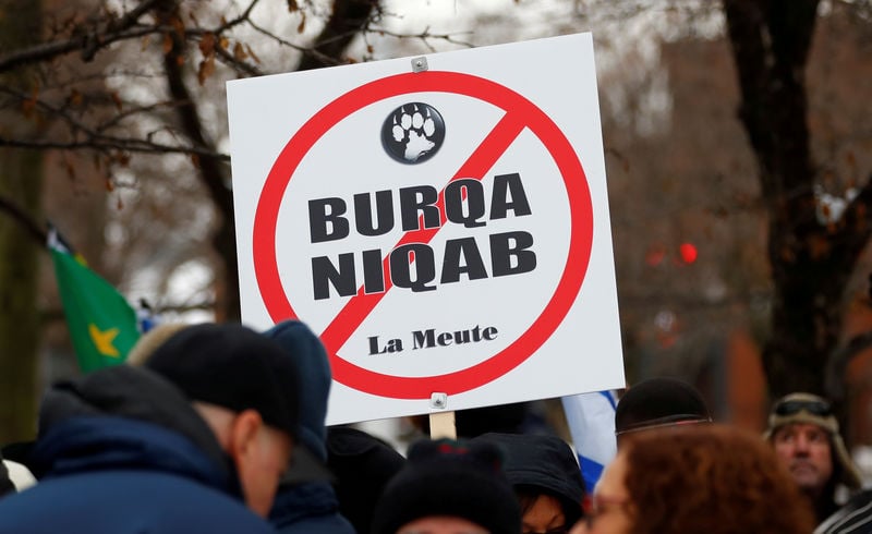 a sign opposing religious attire is displayed during protests by groups la meute and storm alliance in quebec city quebec canada photo reuters