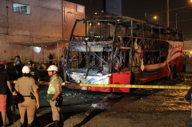 police stand around the charred remains of a bus that caught fire in lima killing 20 people photo afp police stand around the charred remains of a bus that caught fire in lima killing 20 people photo afp