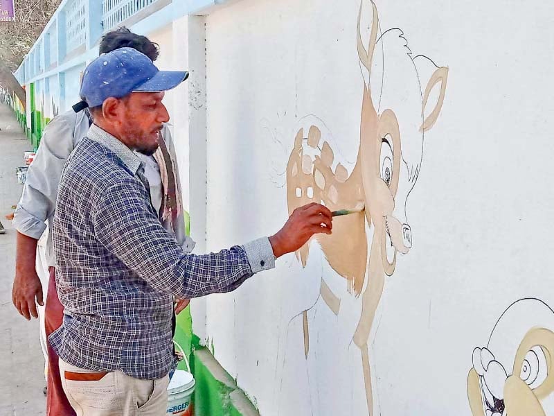 artists paint murals on the outer walls of the karachi zoo as part of its rehabilitation efforts photo ppi