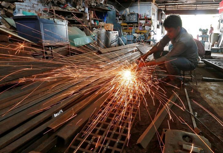 a worker grinds a metal gate inside a household furniture manufacturing factory photo reuters