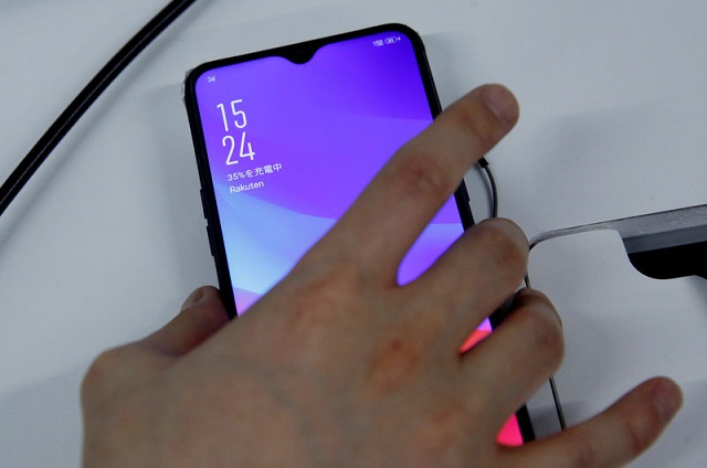 a staff holds a smart phone which being tested for rakuten 039 s under construction mobile network at its network facility in tokyo japan february 20 2019 photo reuters