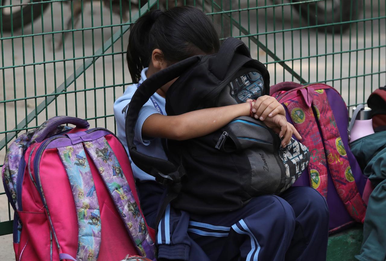 a girl rests her head against a bag outside a school photo reuters