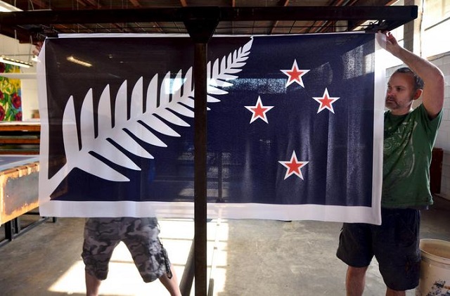 factory workers garth price r and andrew smith l hang new designs of the national flag of new zealand at a factory in auckland new zealand photo reuters
