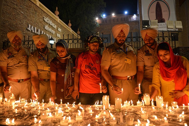 indian punjab police personnel light candles along with local residents as they pay tribute to those killed on the eve of the 100th anniversary of the jallianwala bagh massacre in amritsar on april 12 2019 photo afp