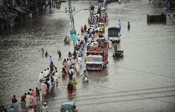 commuters travel through a flooded street in lahore photo afp