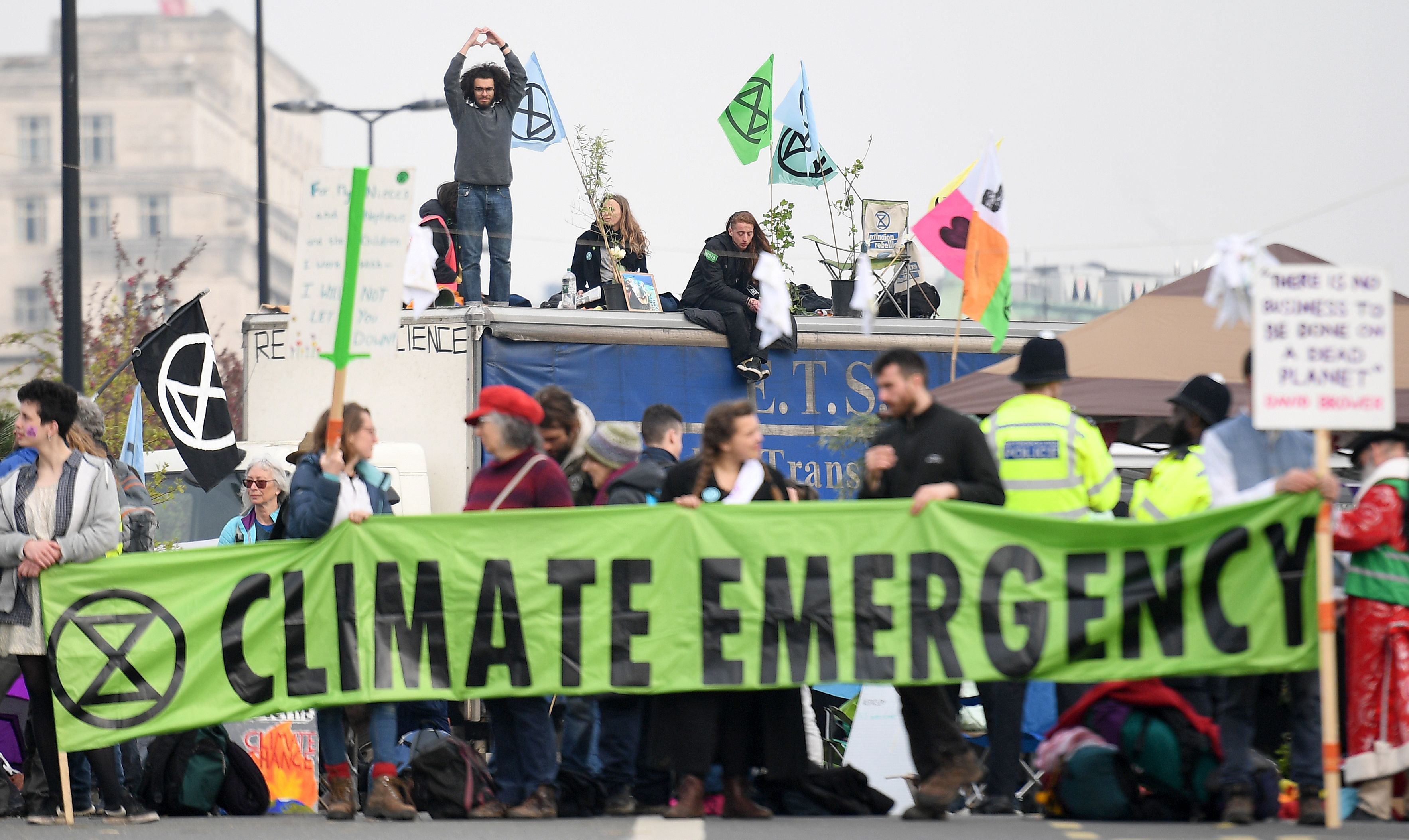 activists hold banners and wave flags as they continue to block the road on waterloo bridge on the second day of an environmental protest by the extinction rebellion group in london on april 16 2019   environmental protesters from the extinction rebellion campaign group started a programme of demonstrations designed to block five of london 039 s busiest and iconic locations to draw attention to what they see as the quot ecological and climate emergency quot of climate change photo afp