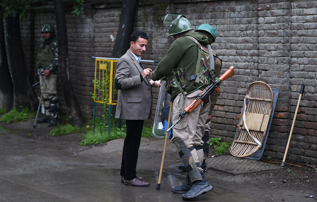 indian paramilitary troopers check the identity card of a polling official outside a polling station photo afp indian paramilitary troopers check the identity card of a polling official outside a polling station photo afp