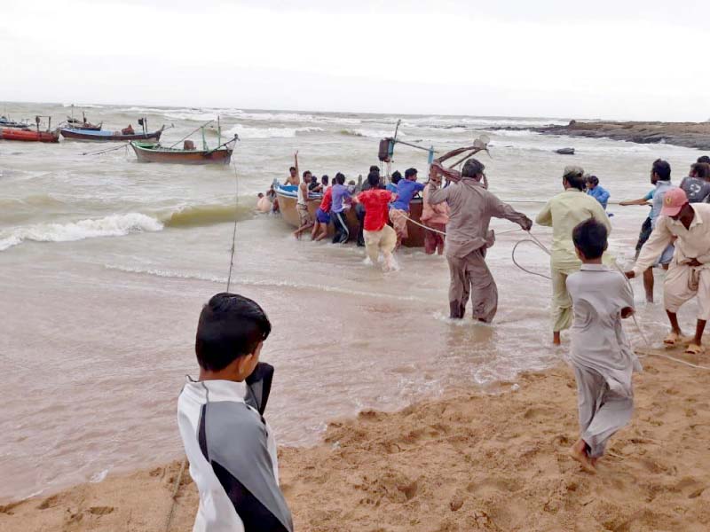 fisher folk at the mubarak village struggle to bring their boats to the shore after the storm winds blowing from the western system left destruction in their wake causing boats to collide capsize and drown photo express