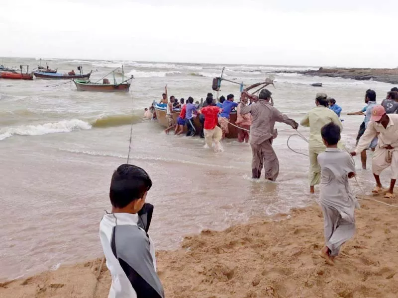 fisher folk at the mubarak village struggle to bring their boats to the shore after the storm winds blowing from the western system left destruction in their wake causing boats to collide capsize and drown photo express fisher folk at the mubarak village struggle to bring their boats to the shore after the storm winds blowing from the western system left destruction in their wake causing boats to collide capsize and drown photo express