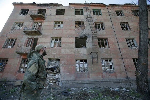 a ukrainian serviceman walks past a building destroyed as a result of shelling by russia backed separatists in the small town of zolote in the lugansk region on april 20 2019 on the eve of the second round of presidential election in ukraine photo afp