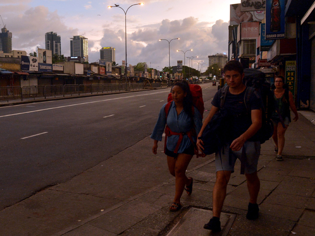 tourists walk along the road after the sri lanka police curfew in colombo on april 21 2019 photo afp