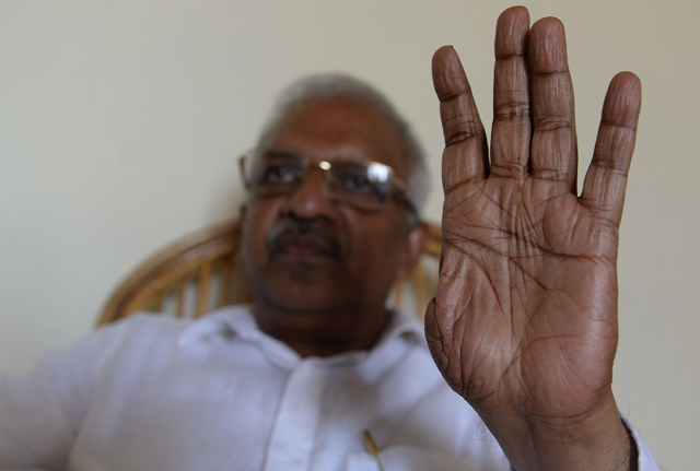 in this photo taken on april 19 2019 p jayarajan a communist party of india marxist electoral candidate and who was a target of political violence in 1999 holds up his thumbless hand during an interview with afp at vadakara in the southern indian state of kerala photo afp