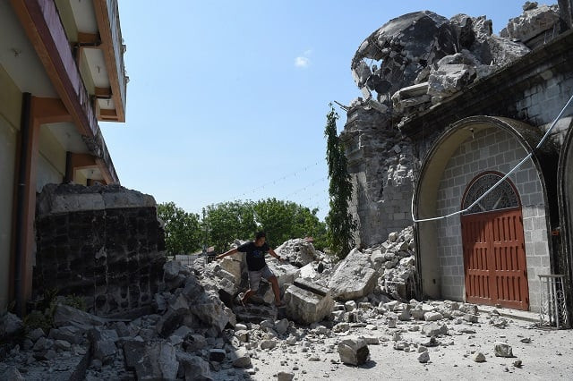 a resident walks past rubble of the 18th century st catherine of alexandria church after its bell tower was destroyed following a 6 3 magnitude earthquake that struck the town of porac pampanga province on april 23 2019 philippine rescuers were scrambling april 23 to reach dozens of people feared buried under a building near manila that collapsed a day earlier in a powerful earthquake as the death toll climbed to 11 photo afp a resident walks past rubble of the 18th century st catherine of alexandria church after its bell tower was destroyed following a 6 3 magnitude earthquake that struck the town of porac pampanga province on april 23 2019 philippine rescuers were scrambling april 23 to reach dozens of people feared buried under a building near manila that collapsed a day earlier in a powerful earthquake as the death toll climbed to 11 photo afp