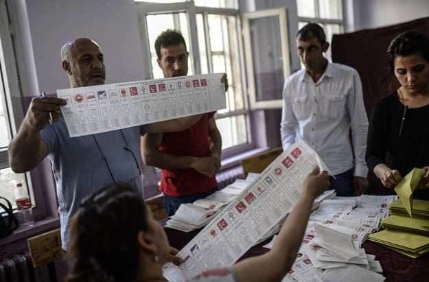 election officials hold ballot papers with the names of political parties participating in the nationwide legislative election as they count votes photo afp