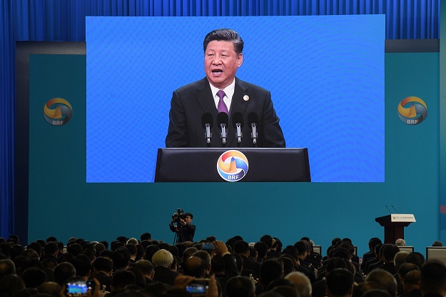 chinese president xi jinping is seen on a screen as he speaks during the opening ceremony of the belt and road forum in beijing in april 26 2019 photo afp