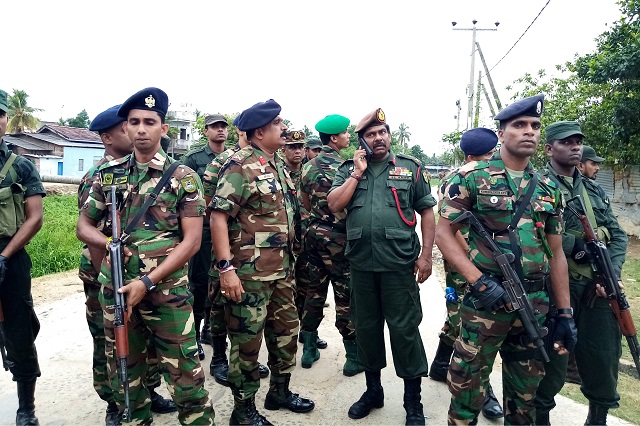 soldiers stand guard in a neighbourhood after they raid what believed to be a militant safe house in the eastern town of kalmunai on april 27 2019   fifteen people including six children died during a raid by sri lankan security forces as three cornered suicide bombers blew themselves up and others were shot dead police said on april 27 photo afp