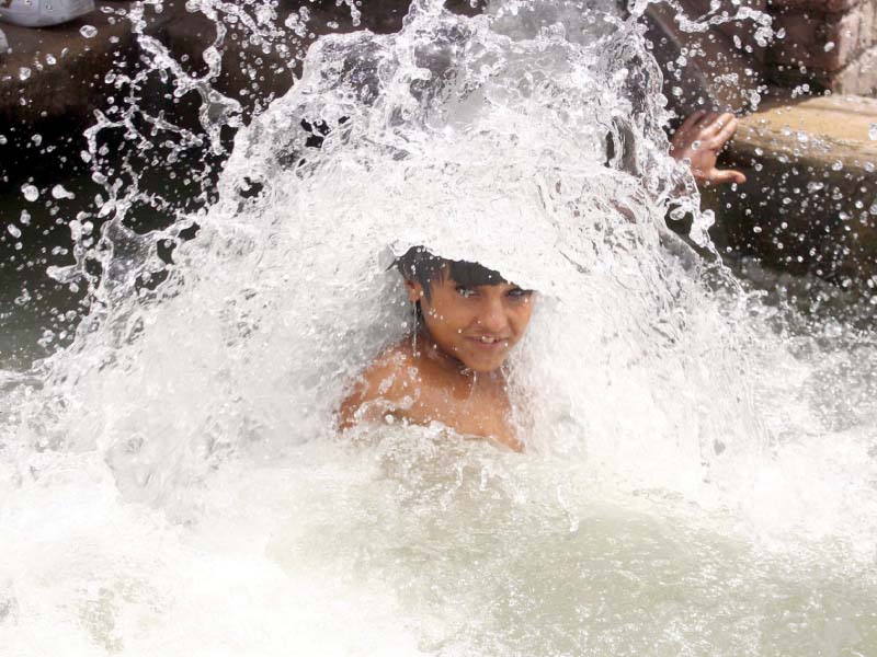 a young boy swims in water to beat the heat pmd has predicted dry and hot weather across the country and possible heatwave from may 1 photo online