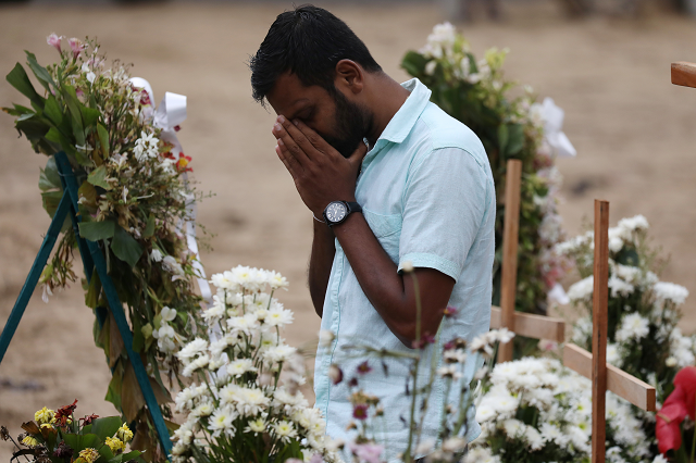 a man reacts during mass burials near st sebastian church in negombo photo reuters a man reacts during mass burials near st sebastian church in negombo photo reuters