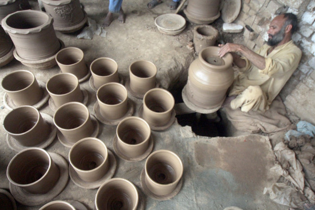 a potter decorating clay pots photo muhammad iqbal the express tribune a potter decorating clay pots photo muhammad iqbal the express tribune