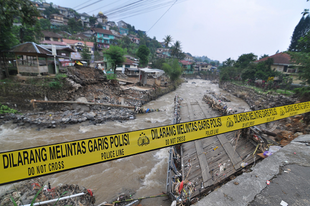a police line is placed at a damaged bridge following torrential rain in bogor west java photo afp a police line is placed at a damaged bridge following torrential rain in bogor west java photo afp