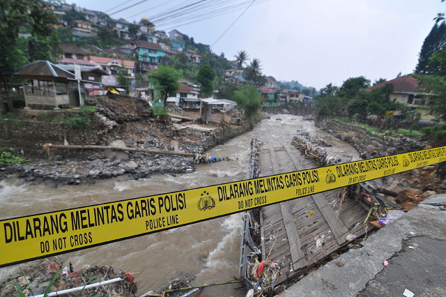 a police line is placed at a damaged bridge following torrential rain in bogor west java photo afp