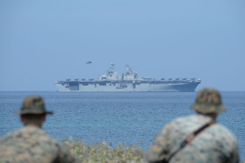 us marines watch the us navy multipurpose amphibious assault ship 039 uss wasp 039 with f 35 lightning fighter jets on the deck during the annual joint us philippines military exercise on april 11 2019 photo afp