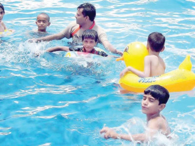 youngsters throng swimming pools as heat soars
