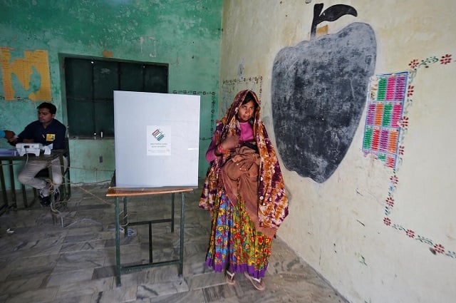 a woman holds her baby as she leaves after casting her vote at a polling station at sirohi district in the desert indian state of rajasthan india april 29 2019 photo reuters