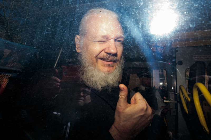 julian assange gestures to the media from a police vehicle on his arrival at westminster magistrates court on april 11 2019 in london england photo reuters