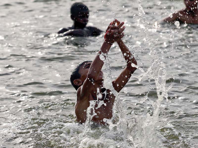 children splash around in a pond in karachi as the heatwave continues its assault photo inp