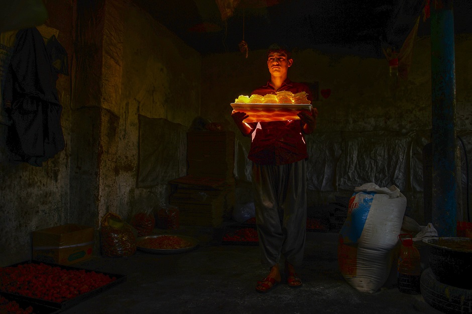 an afghan worker carries sweets at a traditional factory ahead of the start of islamic holy month of ramadan in herat province photo afp