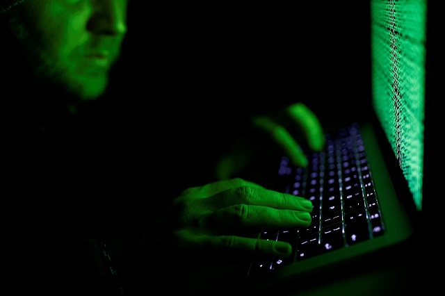 a man types on a computer keyboard in front of the displayed cyber code in this illustration picture taken on march 1 2017 photo reuters