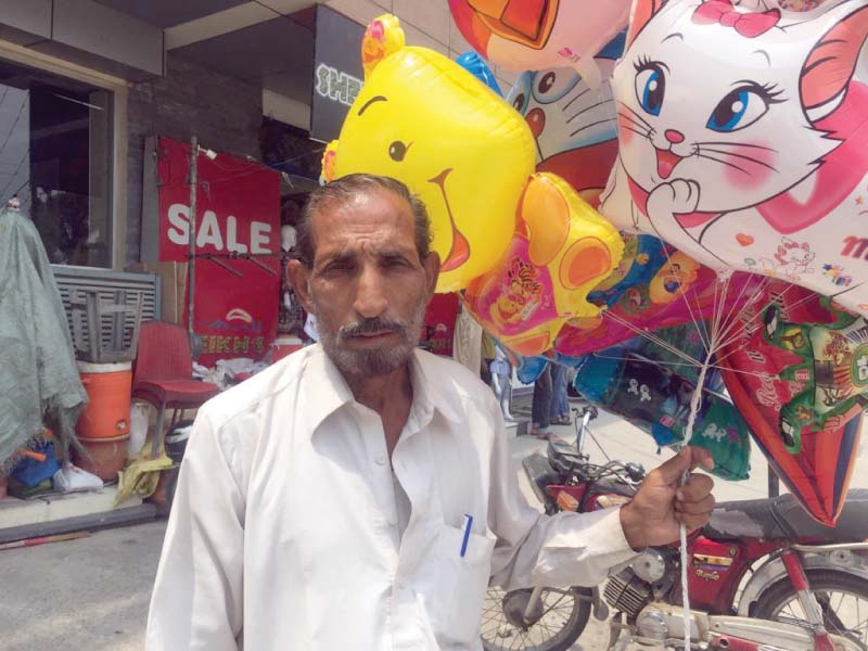 balloon seller akhtar hussain waits for customers on a street in islamabad photo express